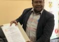 Ketua Harian KONI Kabupaten Mimika, Simon Kasamol, SH saat memperlihatkan SK asli dari KONI Provinsi Papua Tengah