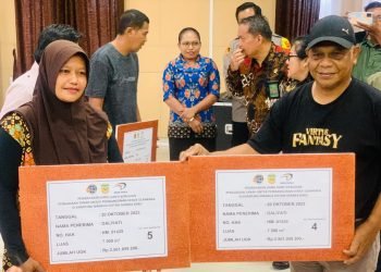 Kepala Dinas Pariwisata Kebudayaan Pemuda Olahraga Kabupaten Mimika Jacob Toisuta saat menyerahkan biaya ganti rugi secara simbolik kepada Daliyati salah satu pemilik sertifikat tanah