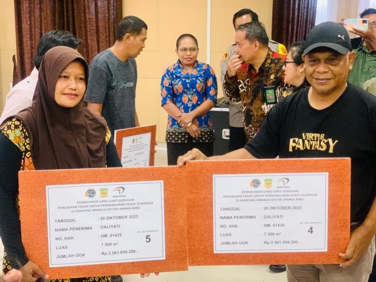 Kepala Dinas Pariwisata Kebudayaan Pemuda Olahraga Kabupaten Mimika Jacob Toisuta saat menyerahkan biaya ganti rugi secara simbolik kepada Daliyati salah satu pemilik sertifikat tanah