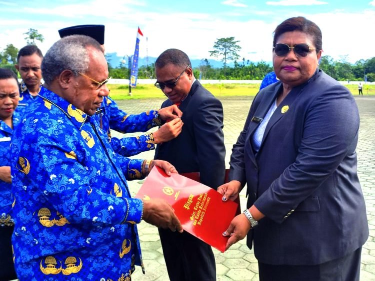 Bupati Mimika Dr. Eltinus Omaleng, SE, MH saat menyerahkan penghargaan kepada Kepala Dinas Tanaman Pangan Hortikultura dan Perkebunan Kabupaten Mimika, Alice Irene Wanma.