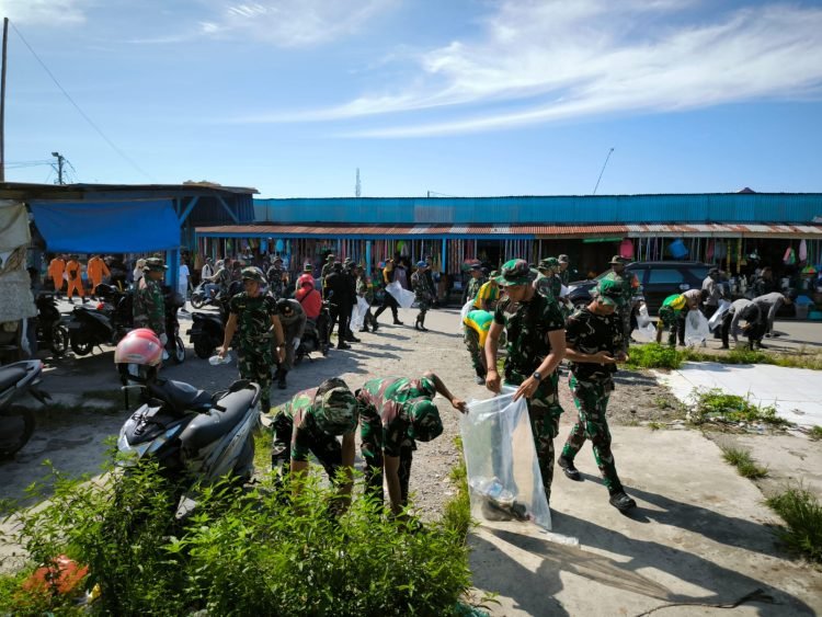Prajurit TNI -Polri saat membersihkan sampah di lokasi Pasar Sentral Timika