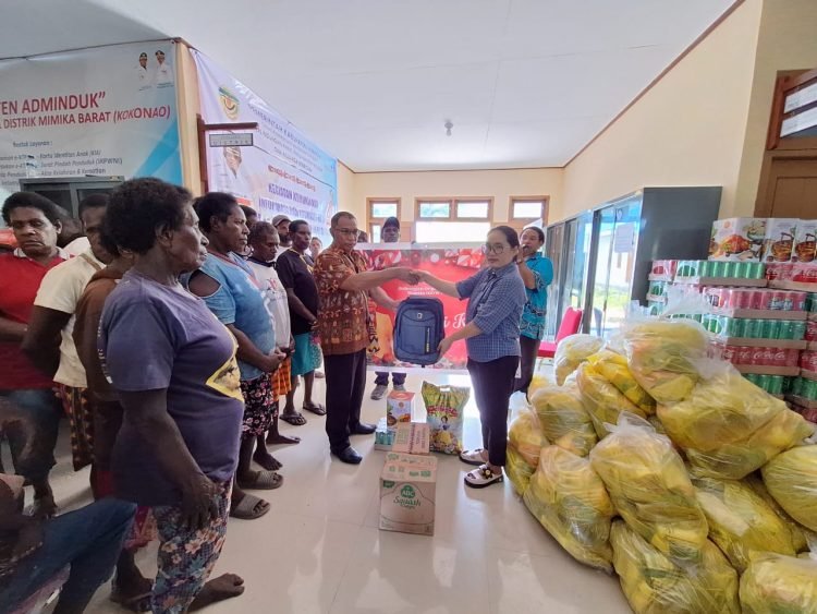 Bendahara GOW Kabupaten Mimika Ny. Herlina Pongdatu saat menyerahkan bantuan kepada Kepala Distrik Mimika Barat Christian Warinussy di Kampung Kokonao