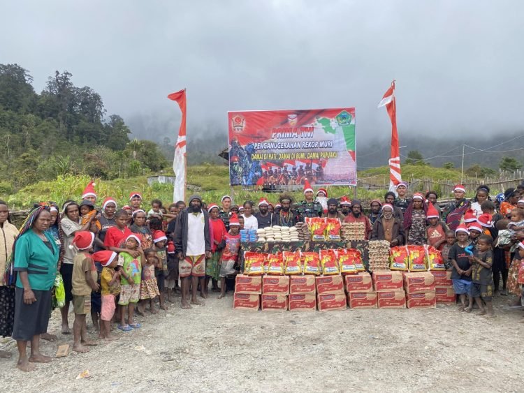Prajurit TNI Satgas 433 Kostrad saat foto bersama dengan warga sebelum membagikan sembako dan makanan bergizi