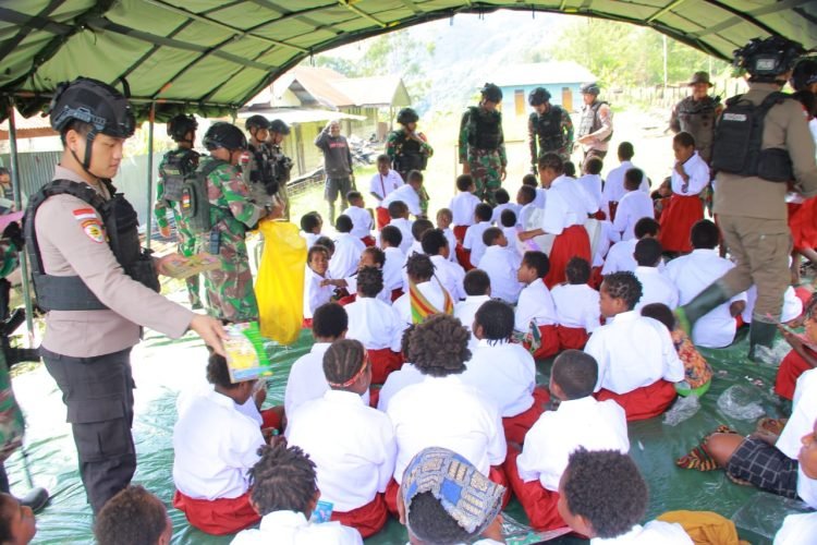 Prajurit TNI/Porli saat mengajar murid-murid SD Inpres Pogapa Distrik Homeyo Kabupaten Intan Jaya