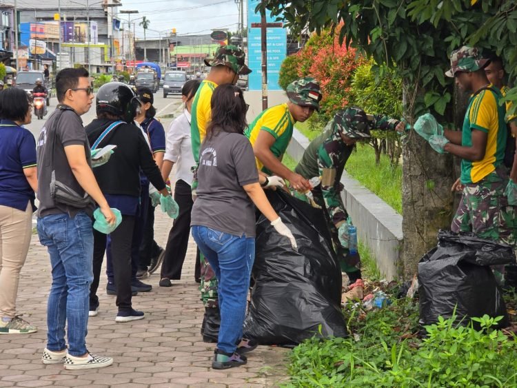 Prajurit Brigif Raider 20/IJK saat bersih-bersih kota bersama pegawai Dinas Perpustakaan dan Arsip Daerah Kabupaten Mimika