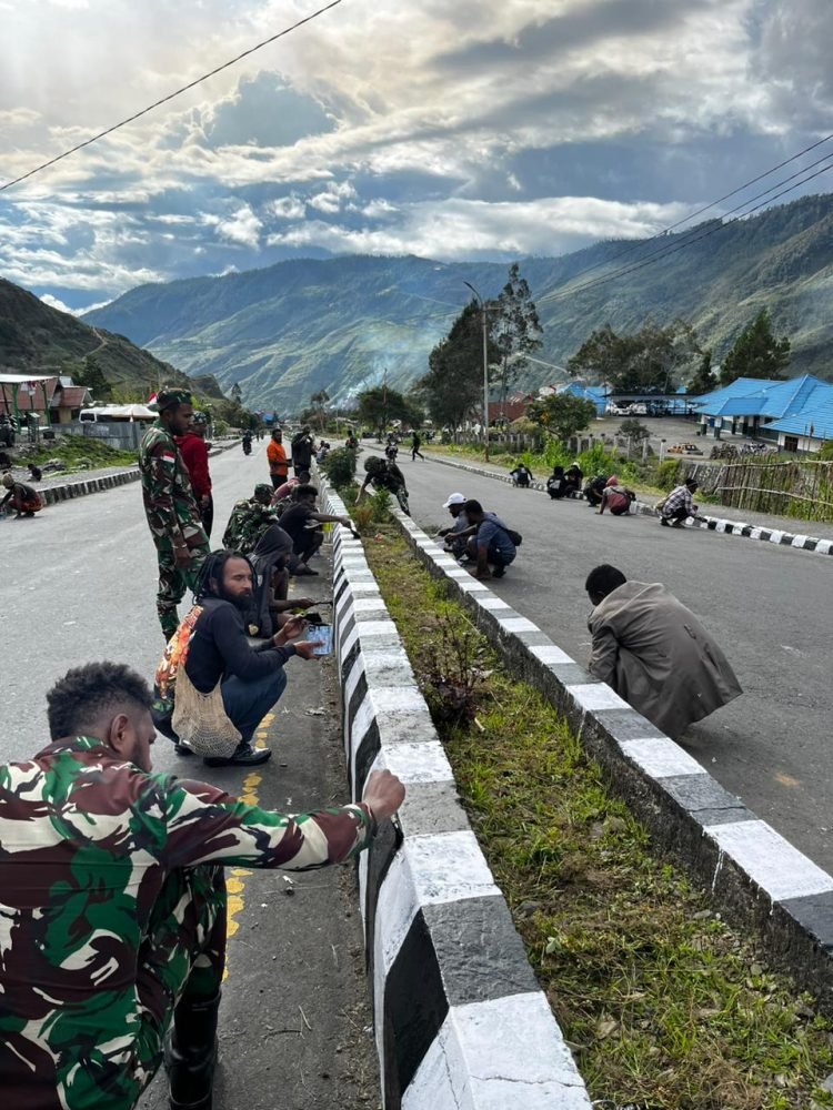 Anggota Satgas Kewilayahan Yonif 715/Motuliato saat kerja bakti bersama warga Puncak Jaya dalam rangka menyambut HUT RI ke-79.