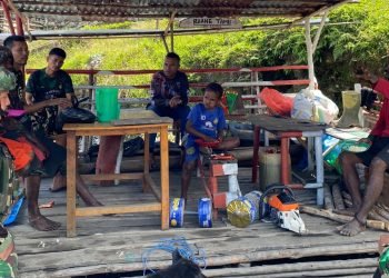 Prajurit Satgas Pamtas Kewilayahan Yonif 715 Motuliato saat memberikan makanan dan pengobatan gratis di Puncak Jaya.